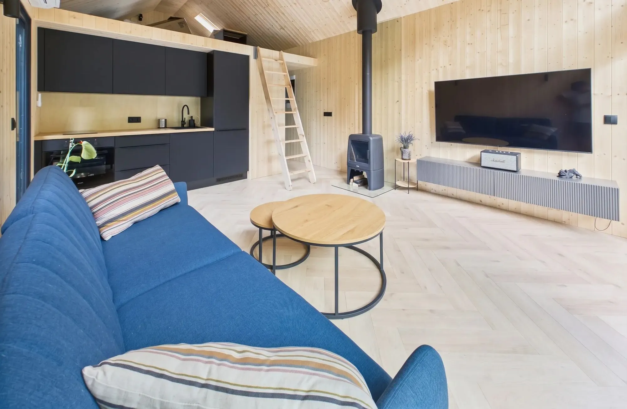 Innenraum eines Modulhauses mit Holzdecke, Galerie und Kaminofen
