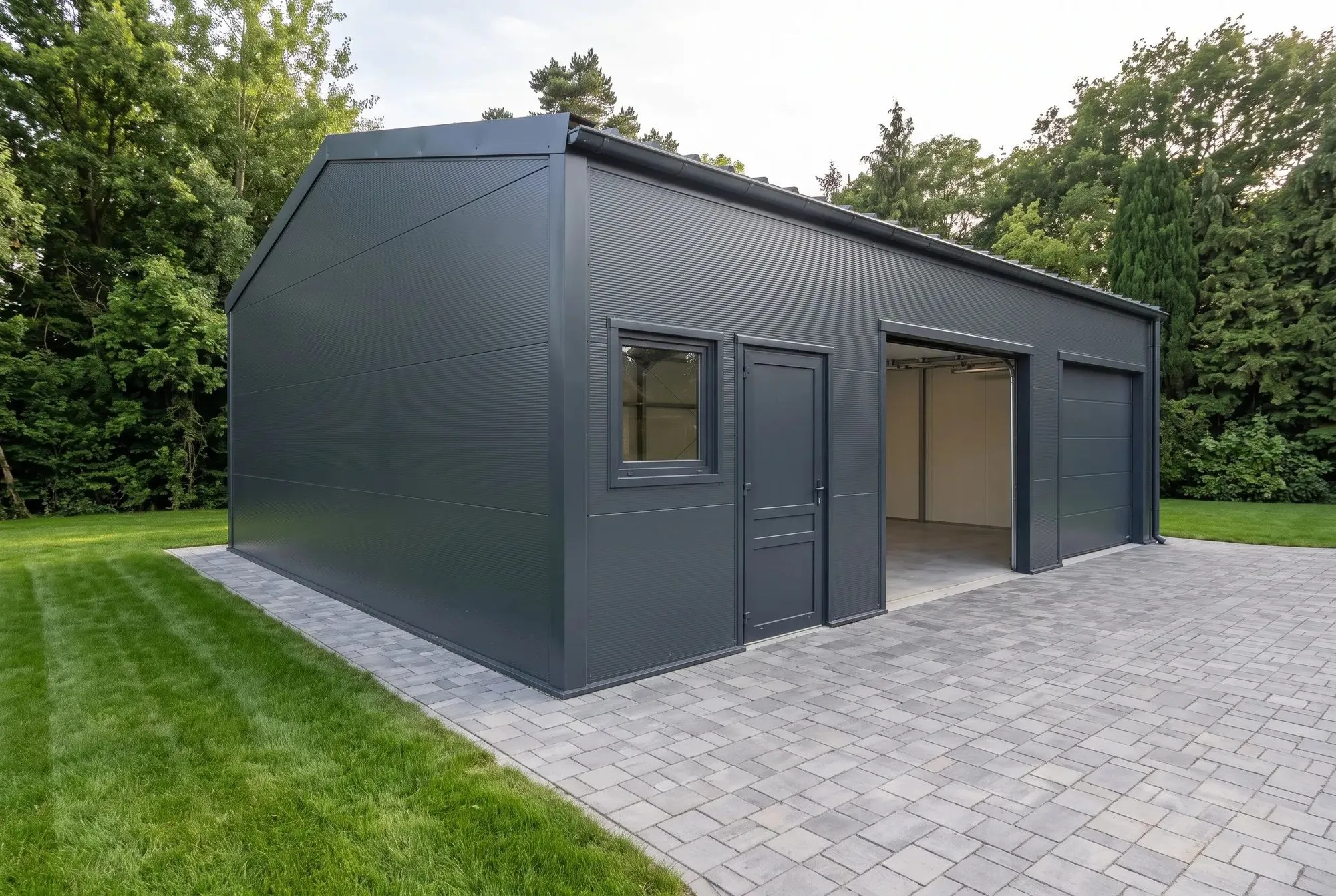 Stahlgarage von der Giebelseite mit Nebentür, Fenster und geöffnetem Tor